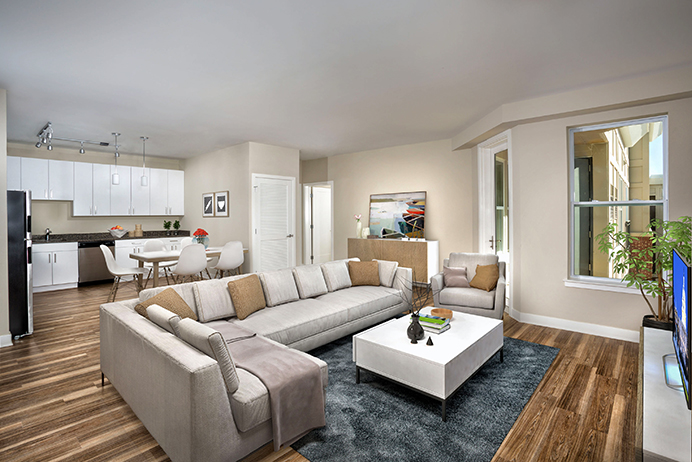 The Remy apartment with white cabinets and plank flooring with open floor plan and large couch seating